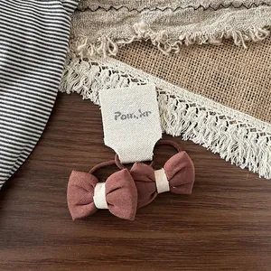 Gros plan de nœuds papillon marron en tissu sur un support en bois aux tons naturels