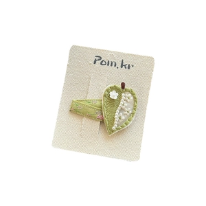 Handmade green knitted leaf hair clip with embroidered white flowers and pearls