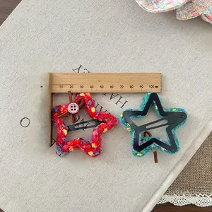 Detail of star-shaped crochet hair clips with measurements showing 5cm length size