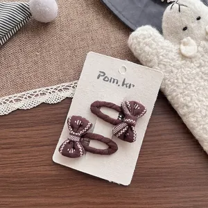 Vue détaillée de barrettes à cheveux en tissu marron faites à la main sur carte