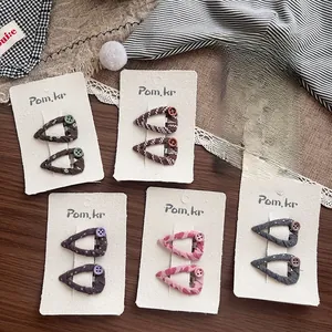 Close-up of handmade fabric triangle hair clips with floral patterns and colorful buttons