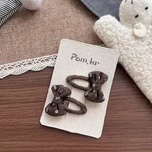 Détail de barrettes à nœuds en tissu floral pour filles sur carte de présentation
