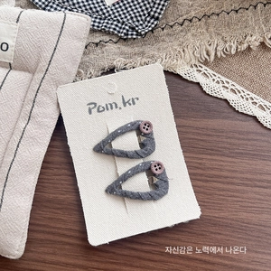 Detailed view of handmade polka dot fabric hair clips with small button embellishments