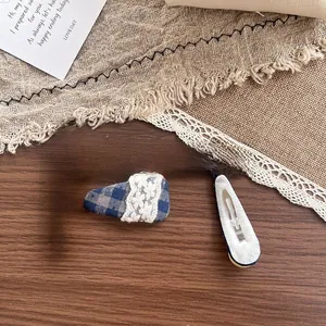 Détail d'une barrette à cheveux en tissu à carreaux bleus de 50 mm avec dentelle