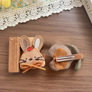 Détails rapprochés de barrettes brodées lapin et carotte avec échelle de règle en bois