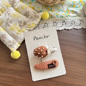 Détail de barrettes à cheveux en tissu avec champignon et bouton sur fond fleuri