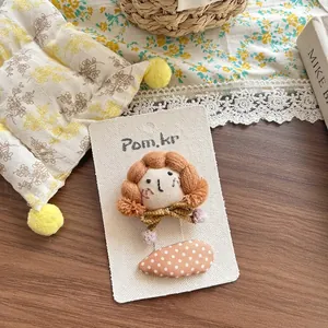 Détail d'une pince à cheveux tricotée à la main avec tissu à pois sur carte cadeau
