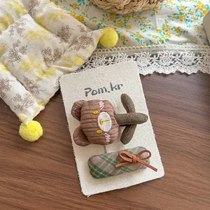 Détail de barrettes brodées ours et tissu à carreaux pour filles sur carte support