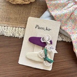 Detalle de pinzas para el cabello de tela para niñas con encaje y lazo de flores