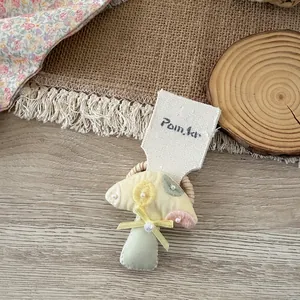 Detailaufnahme der handgemachten Pilz-Haarspange mit Perlen und Schleife auf Karton