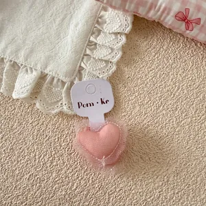 Vue détaillée d'un chouchou cœur rose avec texture en maille douce sur carte support
