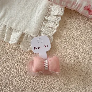 Gros plan d'un élastique rose en tulle avec perles sur carte de présentation de marque
