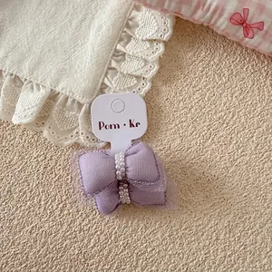 Vue détaillée des nœuds de cheveux en tulle violet avec perles sur carte de support