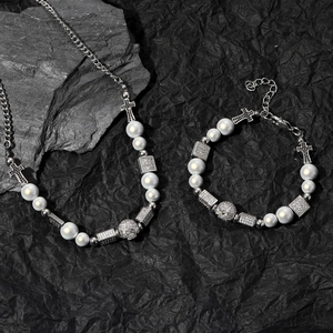 Gotisches Perlenketten- und Armband-Set mit Kreuz- und Totenkopfanhängern auf dunklem Fels