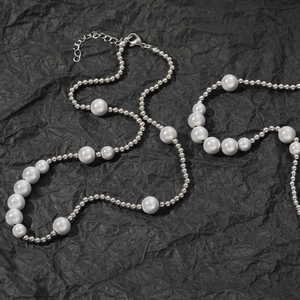 Vue détaillée du collier de perles hip-hop avec perles en acier sur fond noir plissé