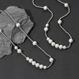 Vue détaillée du collier en acier inoxydable avec perles réfléchissantes sur fond gris