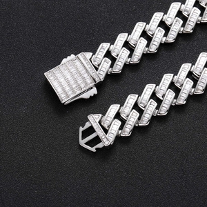 Macro shot of 16mm silver Cuban link chain with baguette-cut stones and clasp detail