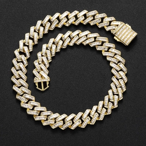 Detailed macro view of 16mm gold cuban link chain with baguette-cut zircon stones