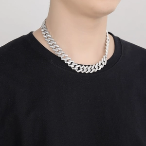 Close-up of 16mm silver Cuban link necklace with baguette-cut stones on male model neck
