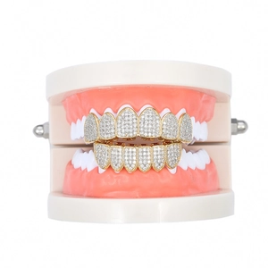 Χρυσά χιπ χοπ grillz με μικροζιργκόν επάνω σε οδοντιατρικό μοντέλο δοντιών για πάρτι
