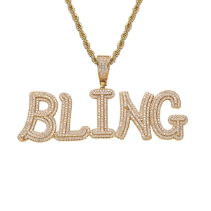 Détail macro d'un pendentif BLING doré avec zircons blancs et chaîne torsadée