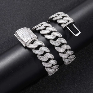 Macro detail of silver Cuban link chain with baguette-cut and pave-set zircons on black stand