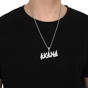 Détail du pendentif lettre AKANA hip-hop argenté avec pierres serties et chaîne corde