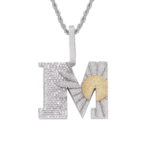 Gros plan du pendentif lettre M hip hop en argent avec zircons et détail de marguerite