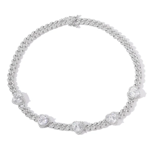 Macro shot of silver Cuban link necklace with five heart-shaped zircons and pave settings