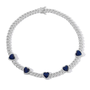 Detailed macro view of silver Cuban link chain with five blue heart zircons and pavé diamonds
