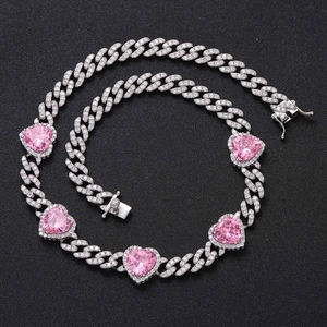 Detail of silver Cuban link necklace with pink heart-shaped stones and pavé zircon settings