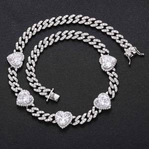 Macro view of silver Cuban chain necklace with heart zircon stones and pavé crystals