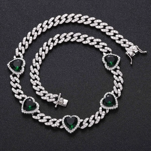 Detail of silver cuban chain with green heart zircon stones and pavé set white crystals
