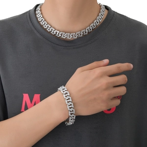 Detail of 13mm silver hip hop Cuban chain set with baguette-cut stones on a model