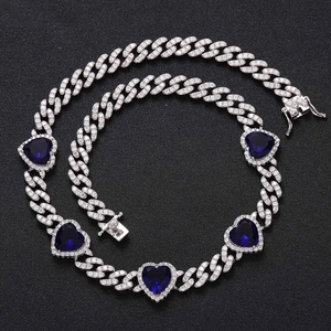 Macro detail of silver Cuban chain necklace featuring heart-shaped blue zircon stones