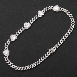 Detail of silver iced out Cuban link necklace with large heart-shaped cubic zirconia charms
