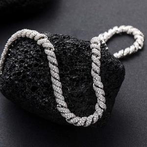 Makroaufnahme der silberfarbenen Kordelkette mit Zirkonia-Besatz auf vulkanischem Gestein