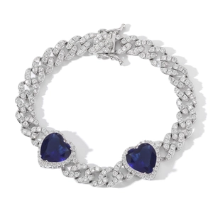 Macro detail of 9mm silver Cuban link necklace with heart blue stones and white zircon