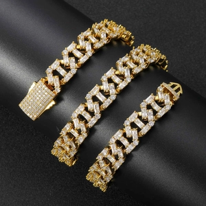 Macro detail of three gold-plated hip hop Cuban bracelets with pavé baguette zircons