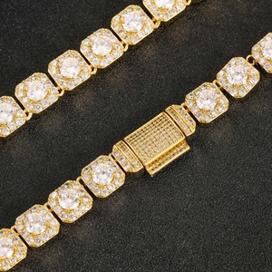 Détail macro d'une chaîne à maillons dorés de 10mm avec zircons et fermoir pavé