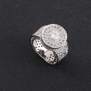 Détail d'une bague hip hop large avec un grand diamant central et pavage de zircons blancs