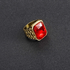 Detalle macro de un anillo hip hop dorado para hombre con un gran rubí rojo rectangular