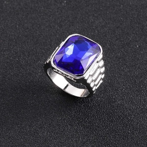 Primer plano de un anillo plateado para hombre con gema azul profundo y banda con ranuras