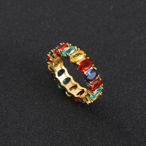 Detail von ovalen Regenbogen-Zirkonia-Steinen auf einem vergoldeten Hip-Hop-Ring für Damen