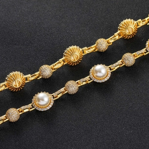 Macro shot of hip hop gold chain with white pearls and sparkling diamond-set sphere elements