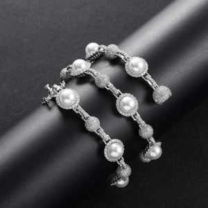 Macro shot of silver hip-hop necklace with pearls and sparkling rhinestone-paved balls