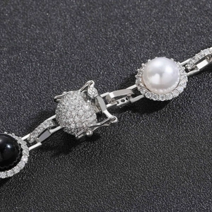 Dettaglio macro di collana hip hop con perle bianche e nere e pavé di zirconi cubici