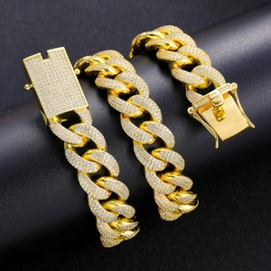 Macro detail of 18mm gold Cuban link chain with micro-pave zircons and secure box clasp