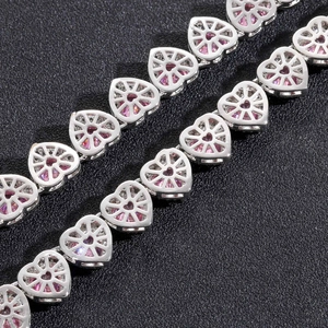 Macro detail of silver heart chain links with micro-paved pink cubic zirconia stones