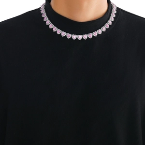 Close-up of pink heart zircon tennis necklace on model featuring silver claw settings